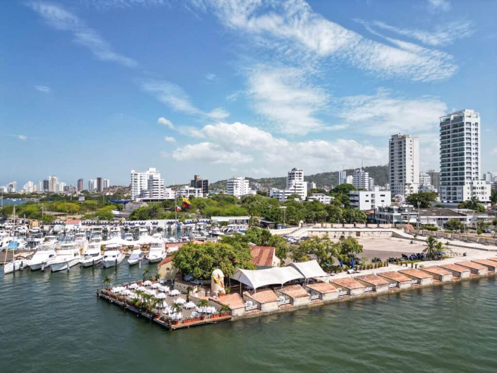 Marina and waterfront restaurants in Cartagena seen from a boat, with the Bocagrande skyline behind