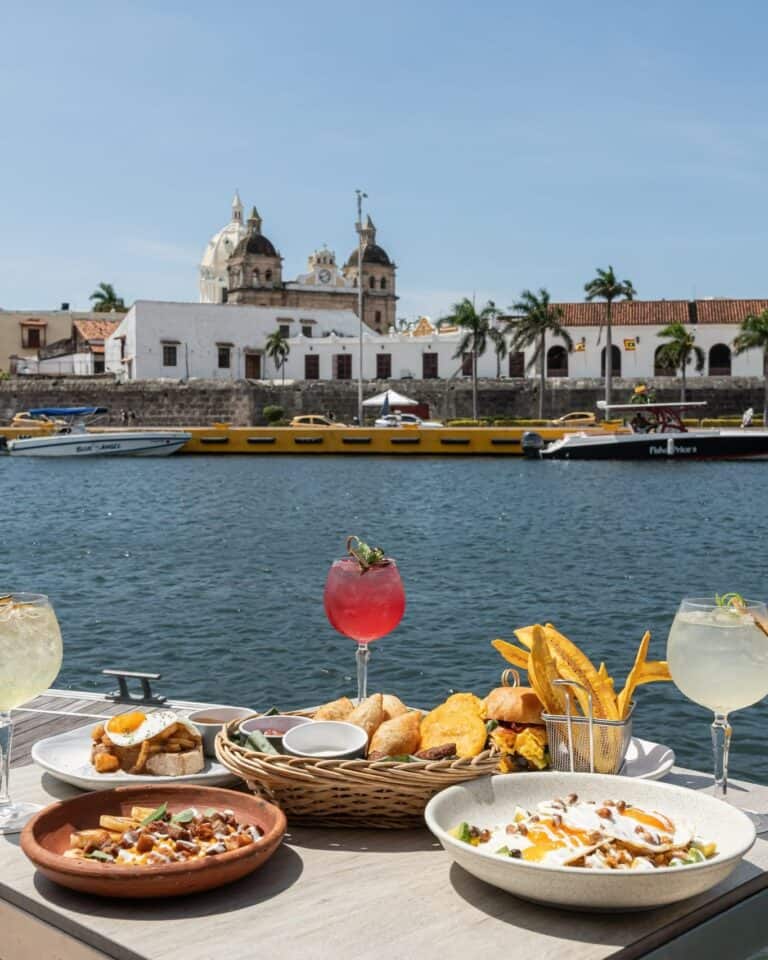 Lunch with cocktails at Restaurante Marea by the bay in Cartagena, with the walled city and San Pedro Claver behind
