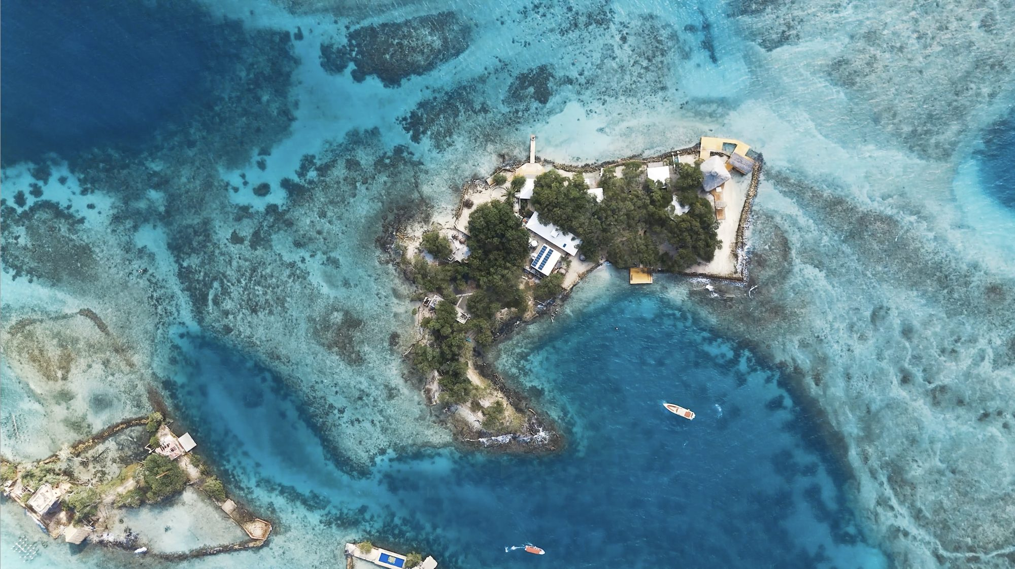 Private island on Isla Grande — top-down aerial over the reef