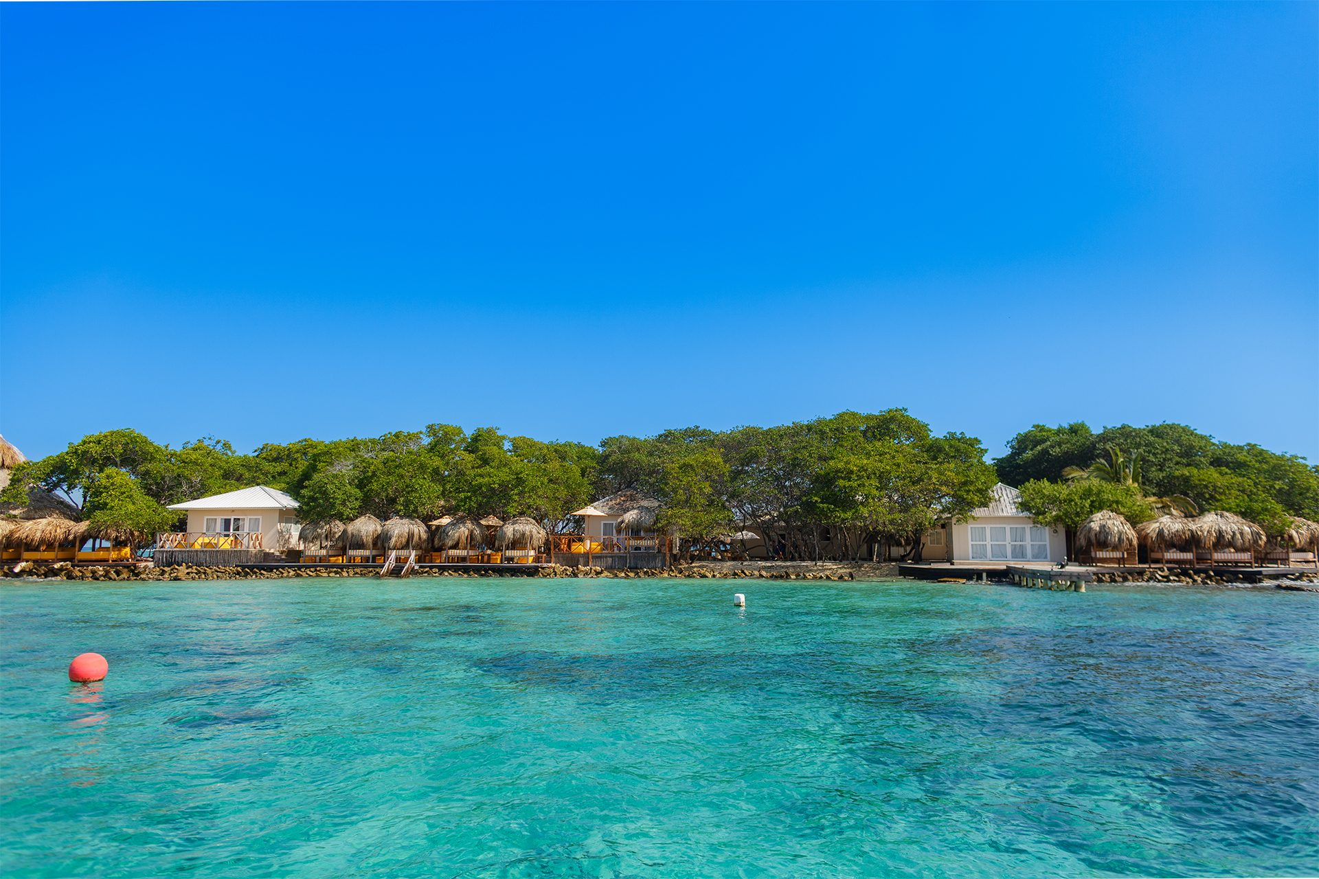 Private island on Isla Grande — beach club dining under umbrellas