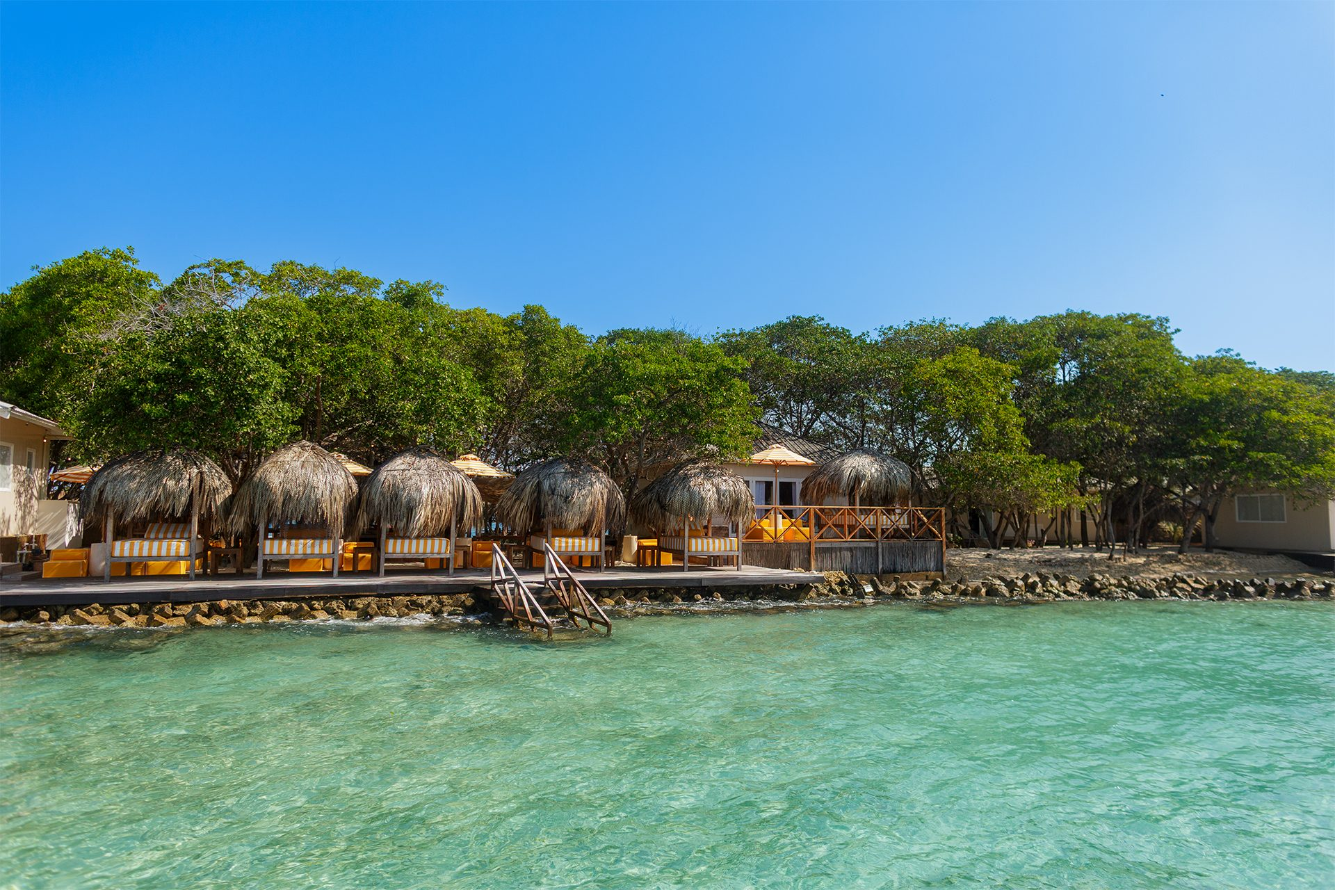 Private island on Isla Grande — beach club dining under umbrellas