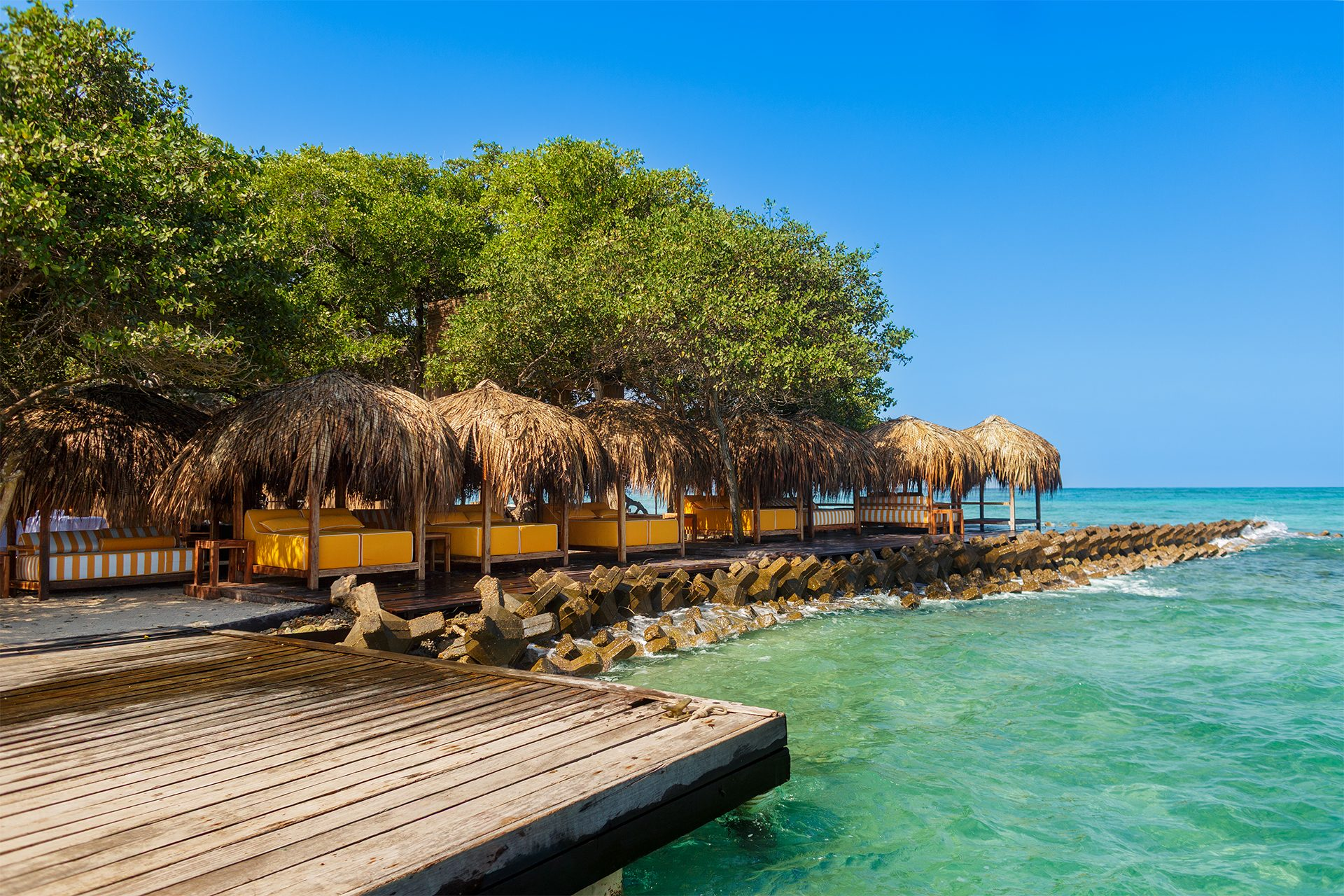 Private island on Isla Grande — beach club dining under umbrellas