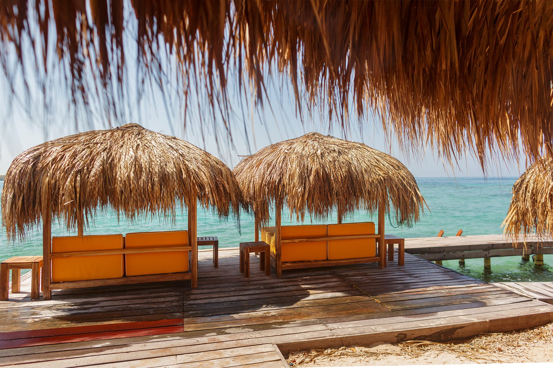 Private island on Isla Grande — beach loungers and palapas by the sea