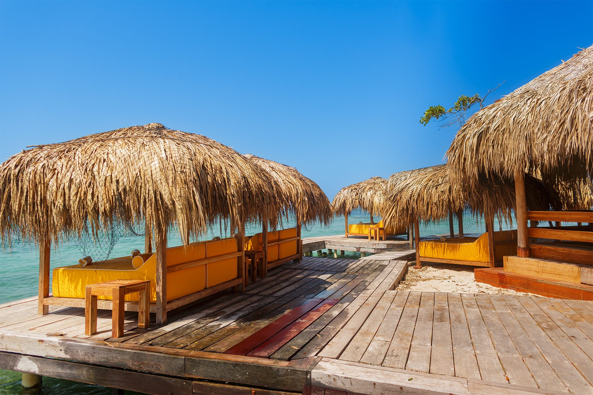 Private island on Isla Grande — beach loungers and palapas by the sea