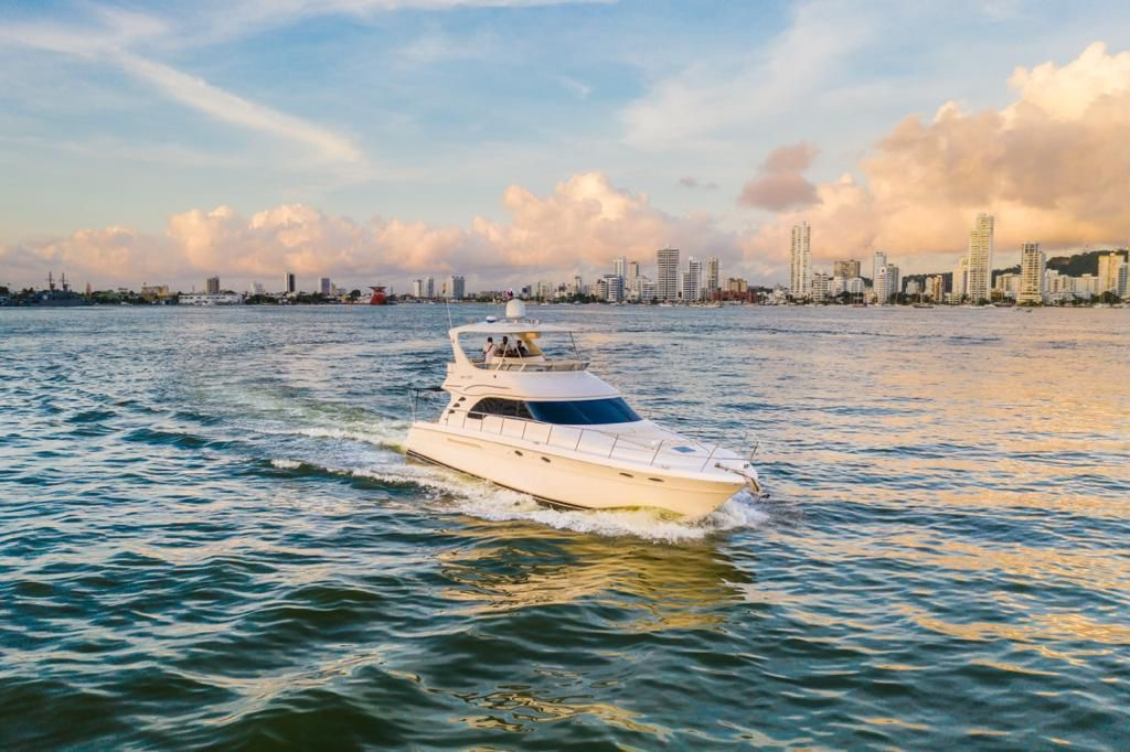 56 ft Sea Ray flybridge yacht cruising at sunset by the Cartagena skyline