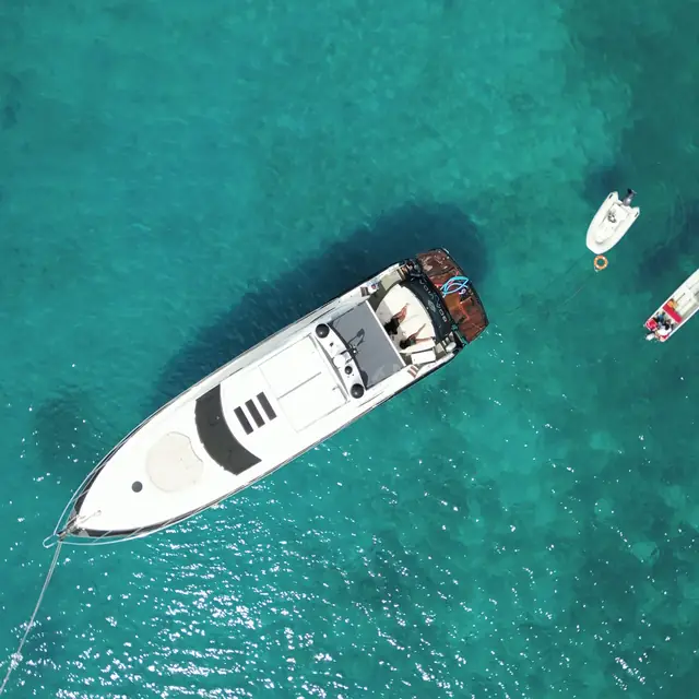 Private yacht anchored in open turquoise water with tenders near Cartagena