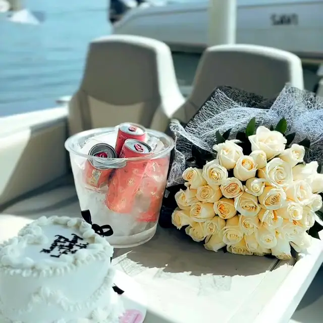 Friends celebrating a birthday with cake and white roses on a private yacht in Cartagena