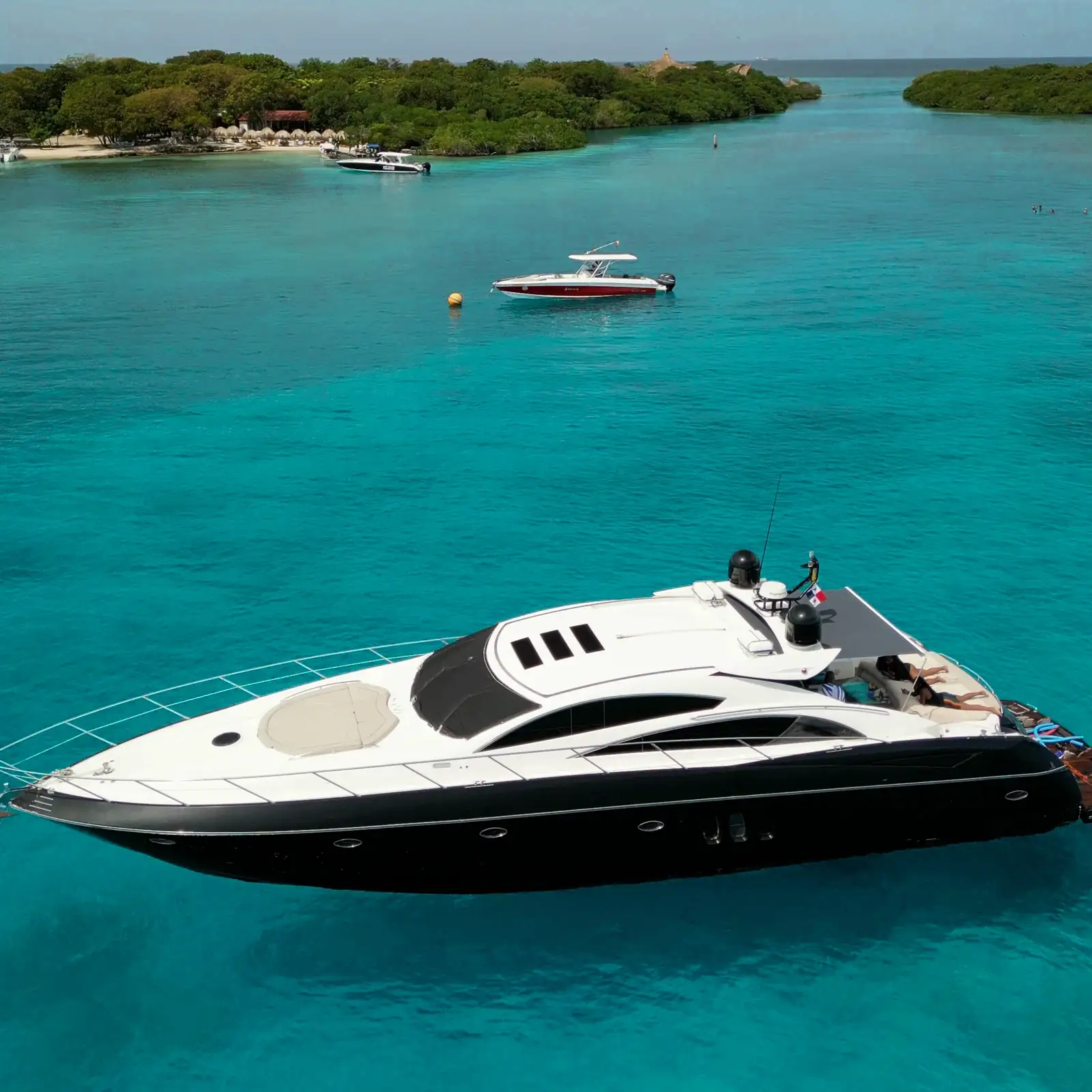 Yacht rental in Cartagena: a private yacht, a speedboat and a beach club in turquoise water
