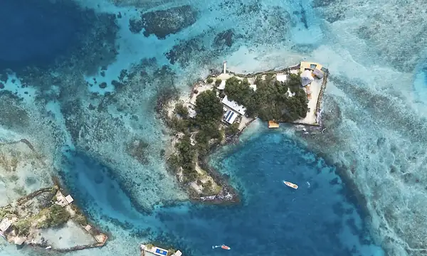 Private island on Isla Grande — top-down aerial over the reef